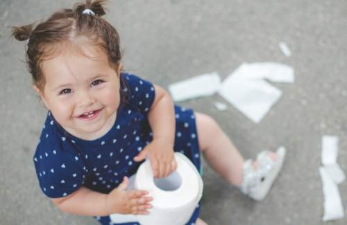 10 Dicas Valiosas para o Desfralde de Fraldas de forma Fácil e Rápida ** Bebe menina brincando com papel higiênico.