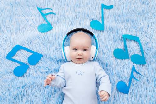 Bebê fofo ouvindo música com fone de ouvido**