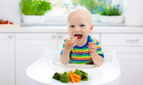 Método BLW: A Revolução que está Libertando Mães do Papinha Industrial! ** Bebê se alimentando de vegetais em cadeirinha