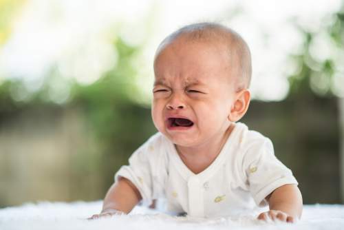 Qual é a diferença entre o choro de fome, sono e desconforto do seu bebê? ** Bebê chorando tristemente.