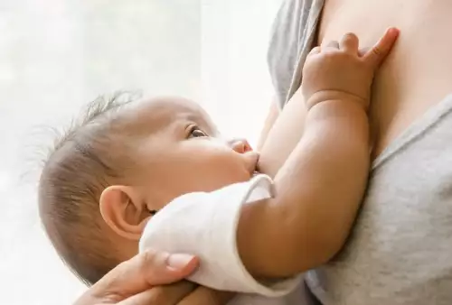 Mãe amamentando bebê com pega correta em ambiente tranquilo